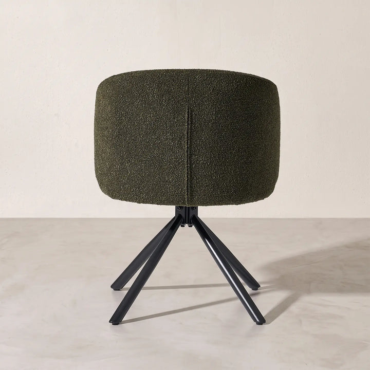 Rear view of the Cleo dark green bouclé swivel chair, highlighting the tailored vertical back seam detail and sturdy 360-degree swivel mechanism.