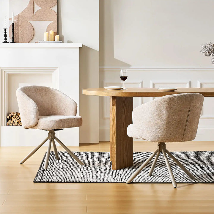 Two Cleo cream Swivel Chairs in front of a dining table in a bright room
