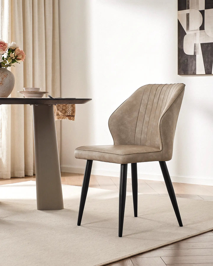 Danforth upholstered dining chair in beige featuring elegant vertical quilted stitching.