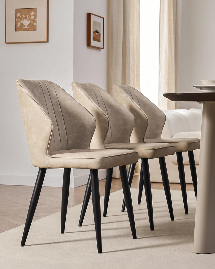 Side-by-side view of three Danforth faux leather chairs showcasing their slim, modern profile.