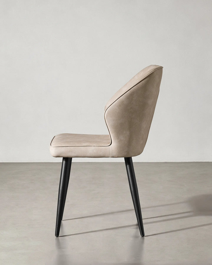 Side profile of the Danforth chair showing the reclined backrest and sturdy black metal legs.