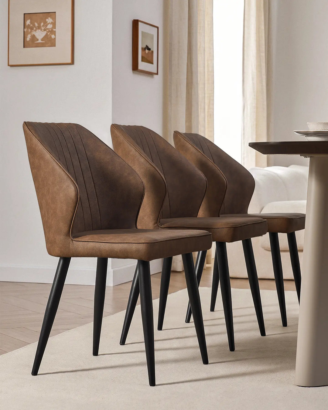 Side-by-side view of three Danforth faux leather chairs showcasing their slim, modern profile.