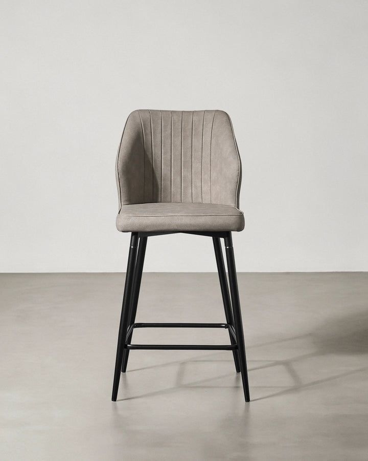 Front view of a Danforth Light Grey bar stool with a curved padded backrest, upholstered seat and slim black metal legs