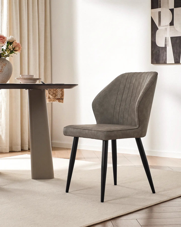 Danforth upholstered dining chair in light grey featuring elegant vertical quilted stitching.
