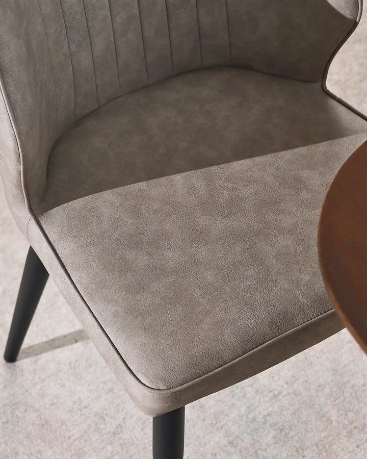 Detail shot of the durable beige faux leather and high-density foam seat of the Danforth chair.