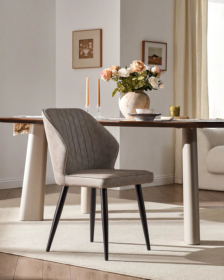 Contemporary Danforth dining chair with black tapered metal legs in a bright dining room setting.