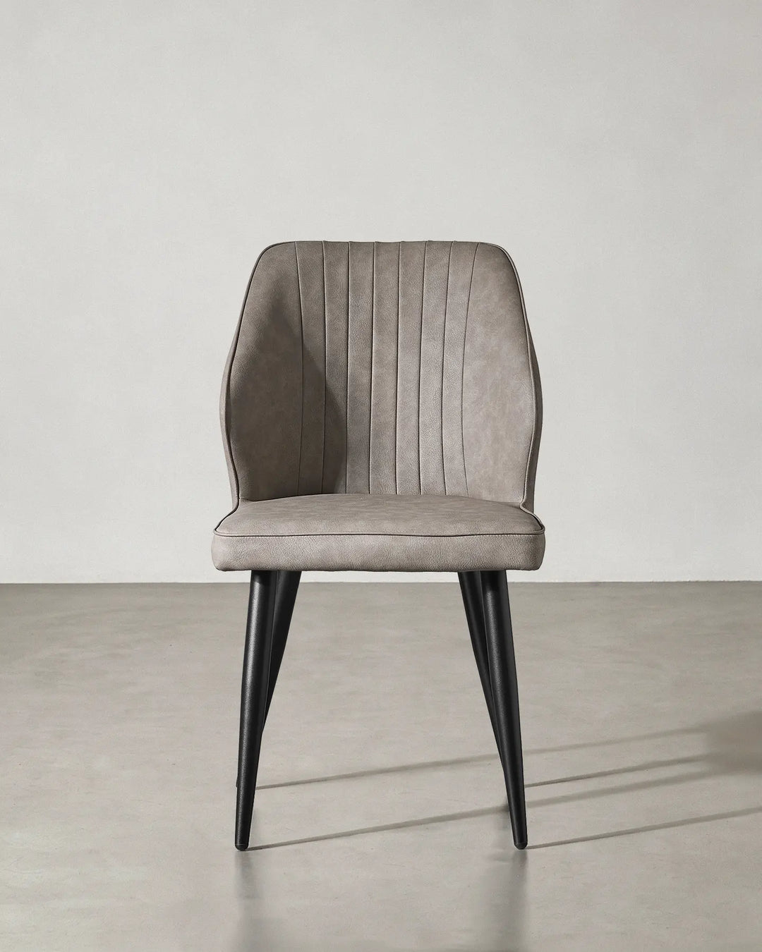 Front view of the Danforth faux leather chair highlighting its symmetrical contemporary design.