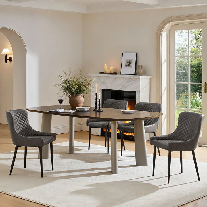 Set of four grey faux leather dining chairs beside a dining table in a contemporary dining interior