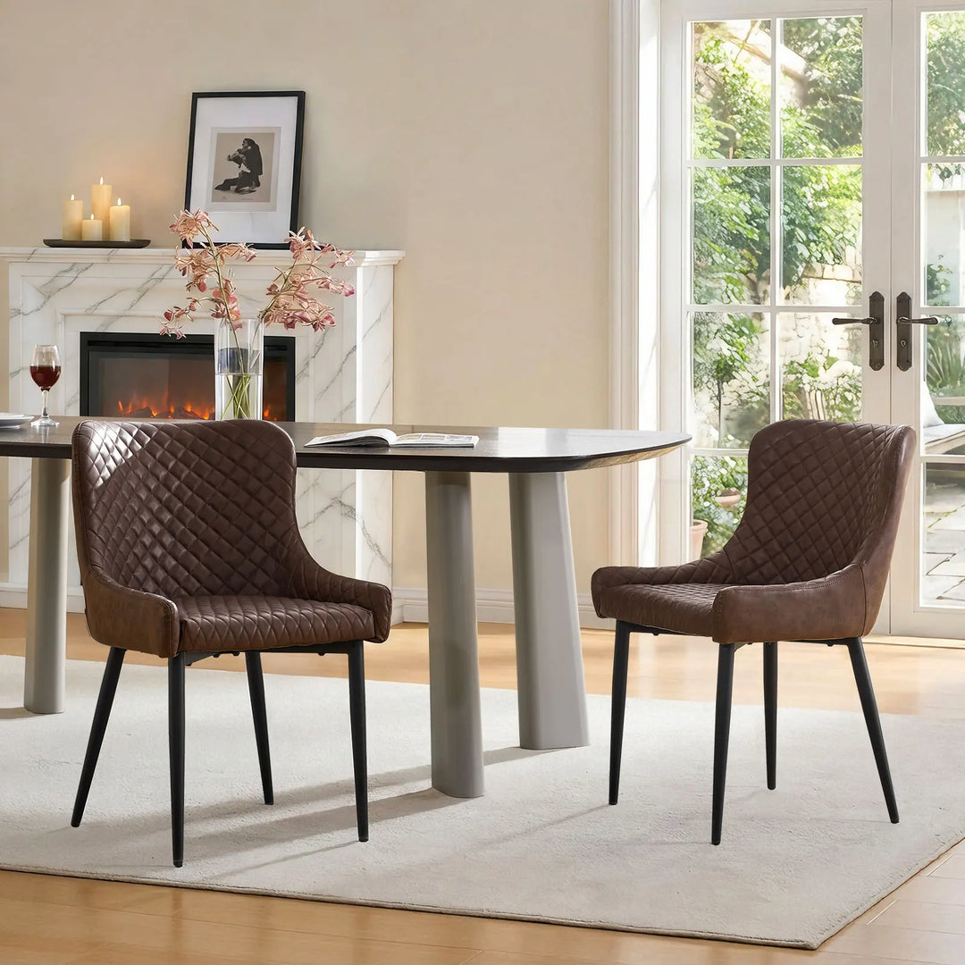 Pair of brown faux leather dining chairs styled next to a dining table in a contemporary dining space