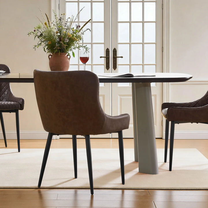 Three brown faux leather dining chairs surrounding a dining table, highlighting the smooth curved back design