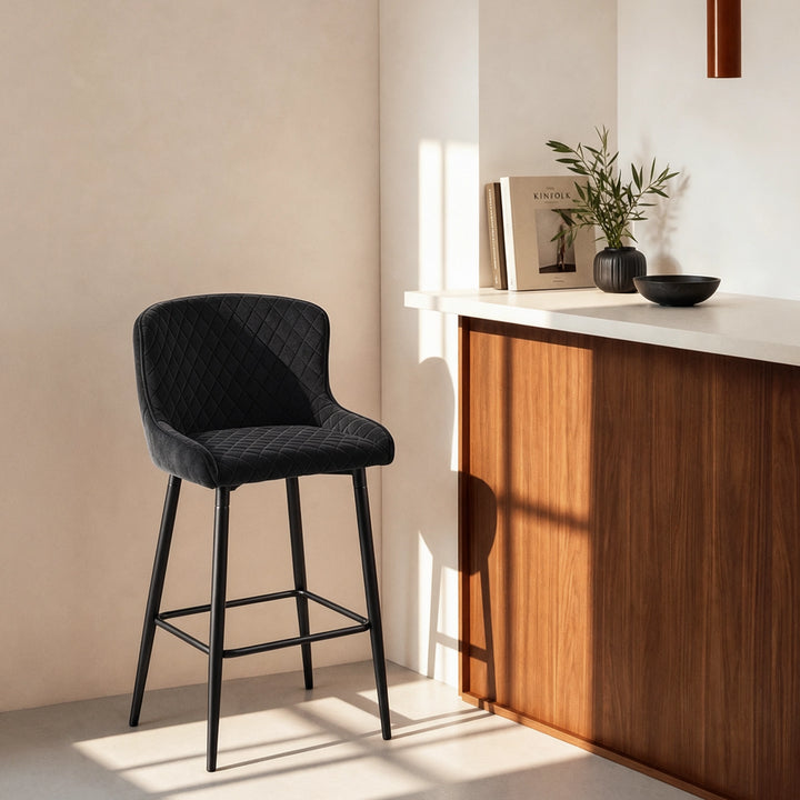 Dundas Black Velvet Bar Stools beside a bar