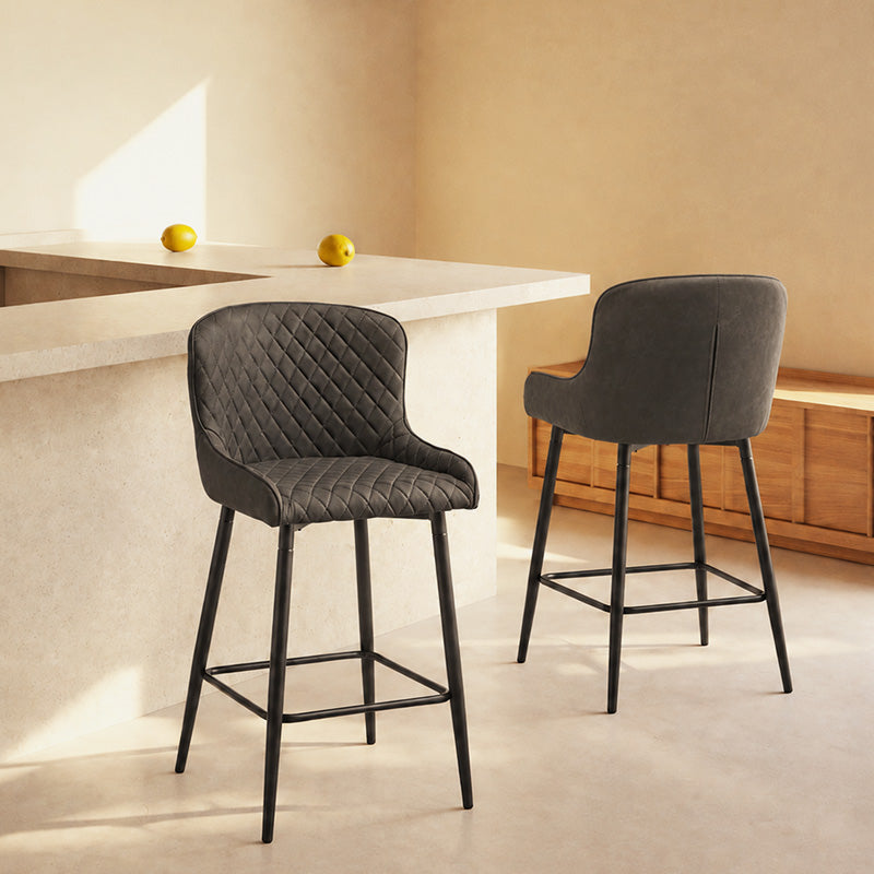 A set of 2 bar stools in the kitchen area, featuring a curved back and black metal legs