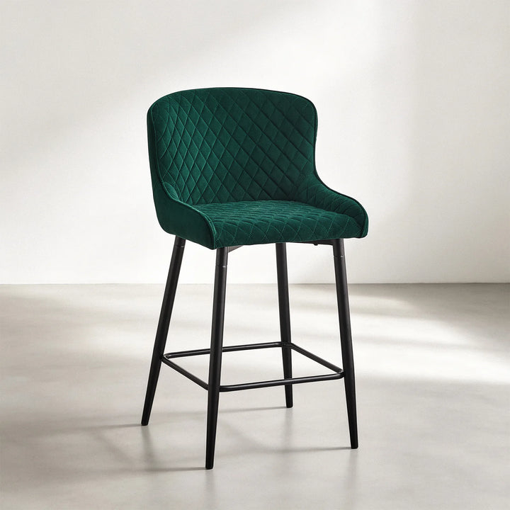 Dundas green velvet bar stool with diamond quilted upholstery, curved backrest and black metal legs