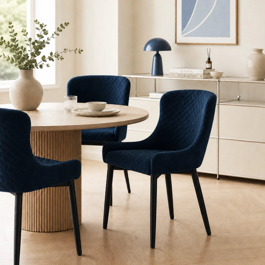 Dundas Velvet Dining Chairs with black metal legs, in a bright dining area
