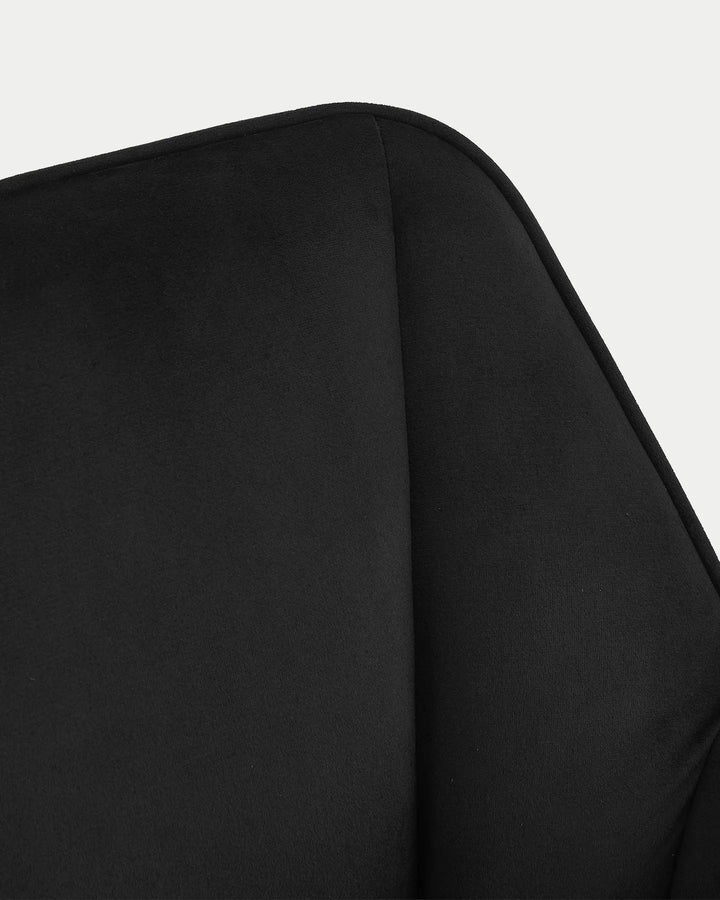 Detailed view of the Earven black velvet dining chair highlighting the upholstered armrest, smooth fabric finish and neat edge stitching