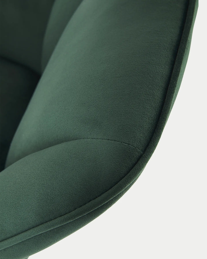 Detailed view of the Earven green velvet dining chair highlighting the upholstered armrest, smooth fabric finish and neat edge stitching