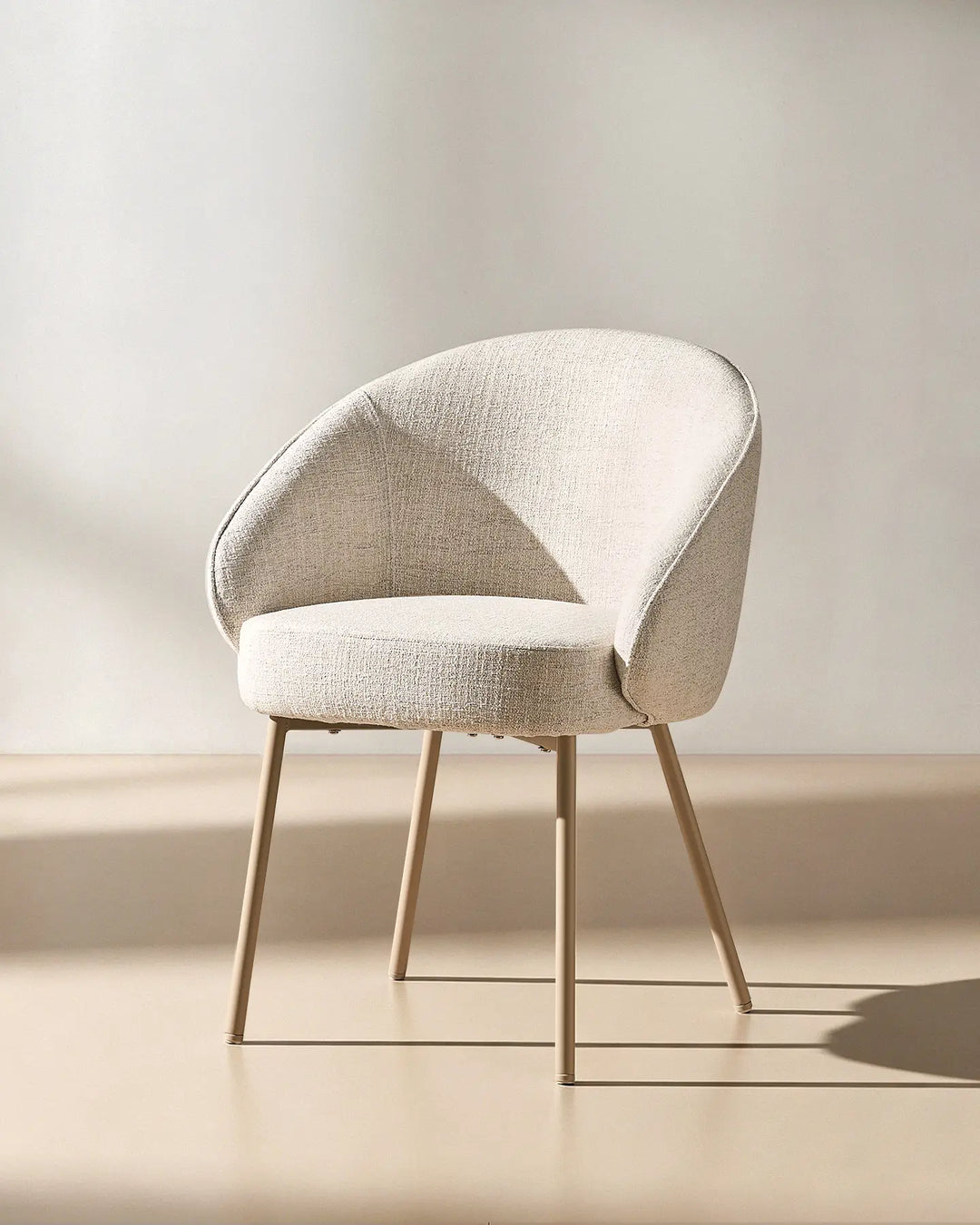 45 degree view of the Elowen beige linen dining chair highlighting its comfortable padded design and elegant profile