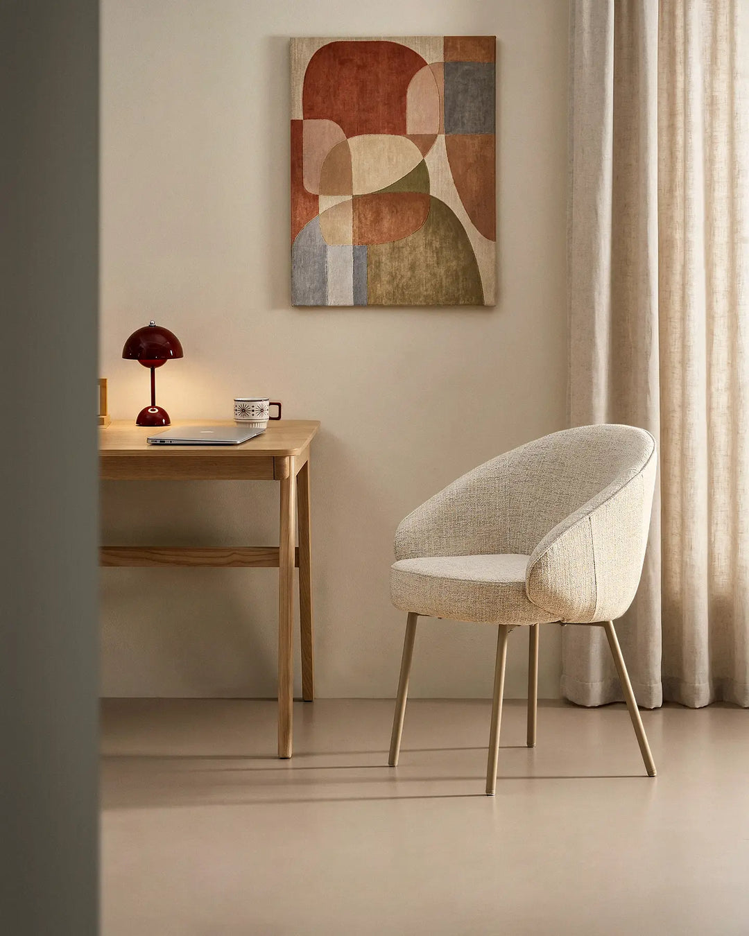 Elowen beige linen dining chair used as a comfortable home office chair with thick padded seat and curved armrests beside a modern desk