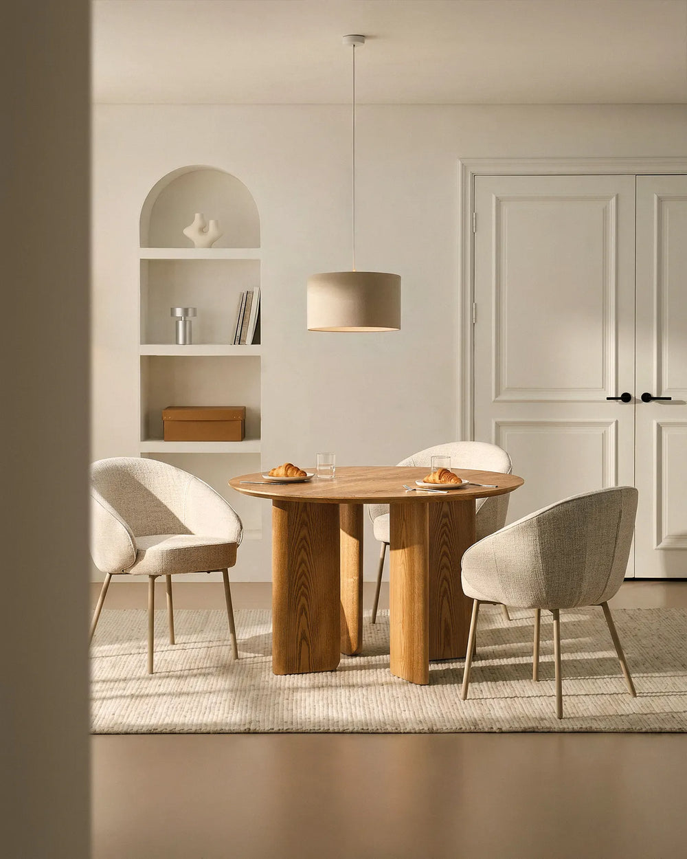 Three Elowen beige linen dining chairs around a dining table, featuring thick padded comfort and timeless Scandinavian style