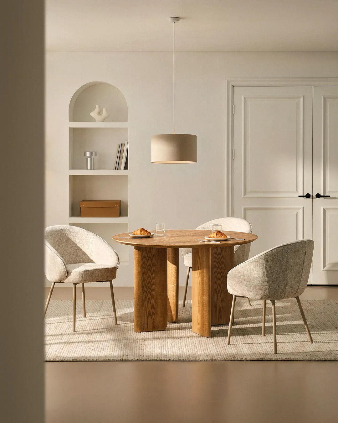 Three Elowen beige linen dining chairs around a dining table, featuring thick padded comfort and timeless Scandinavian style