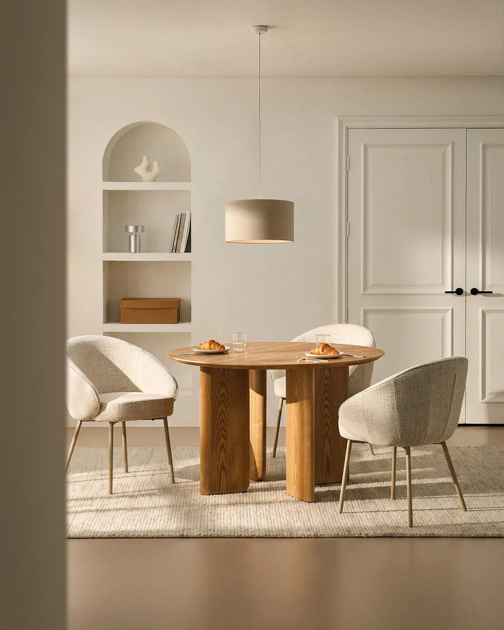 Three Elowen beige linen dining chairs around a dining table, featuring thick padded comfort and timeless Scandinavian style