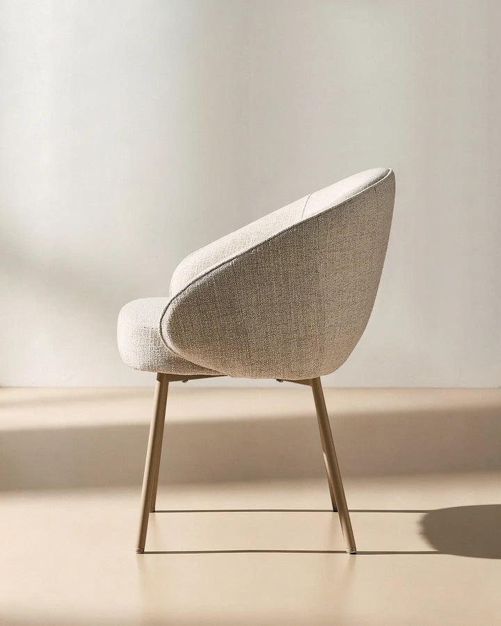 Side view of the Elowen beige linen dining chair showing its supportive curved back and thick upholstered seat