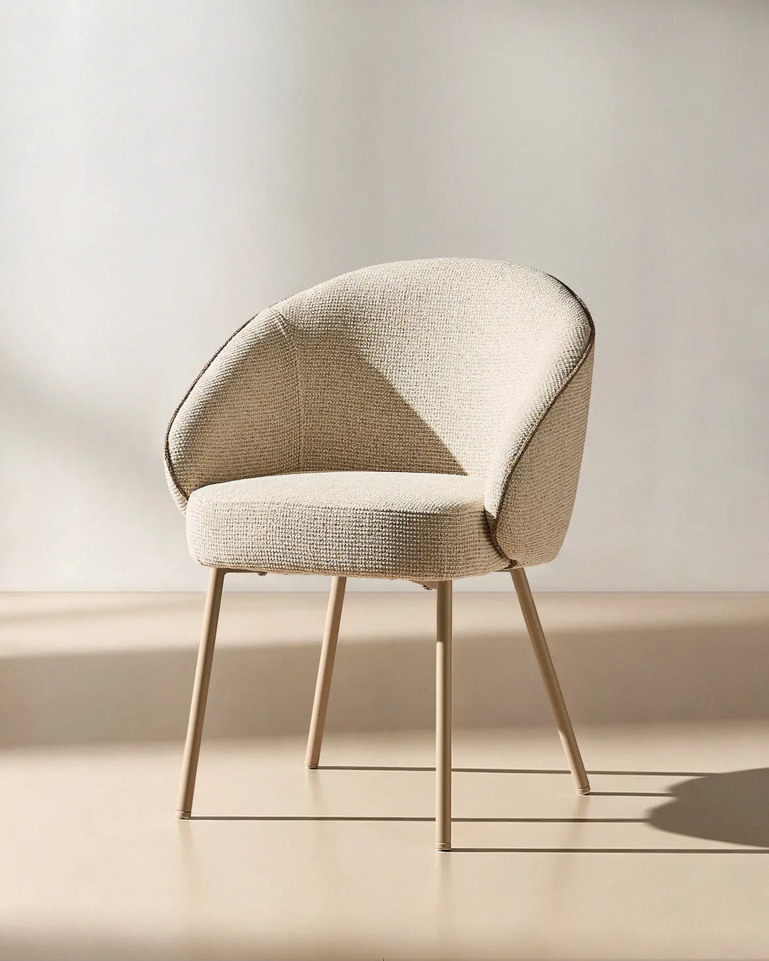 45 degree view of the Elowen cream and brown chenille dining chair highlighting its thick padded comfort and elegant profile