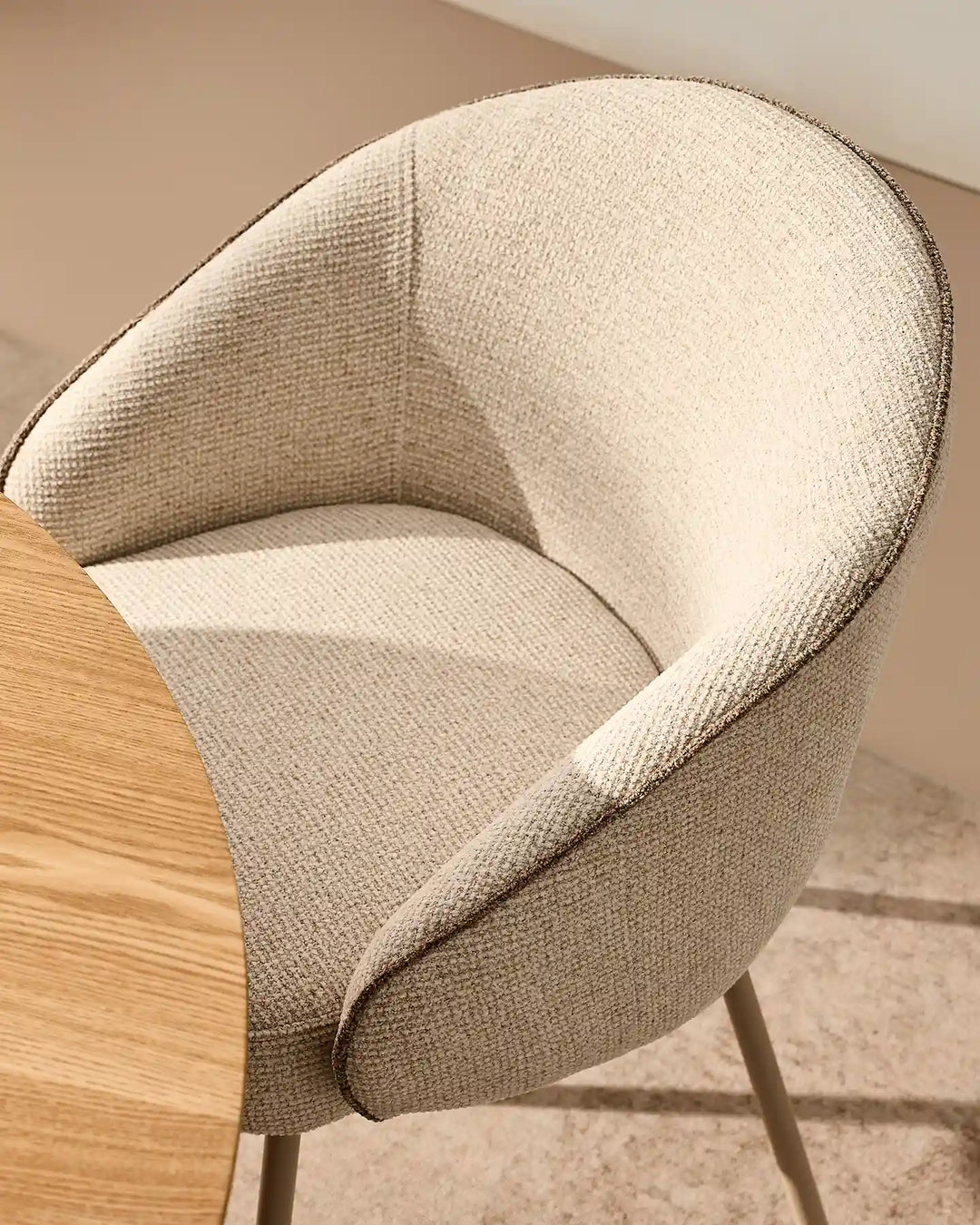 Close-up of the Elowen cream and brown chenille dining chair showing thick padded upholstery and rounded armrests