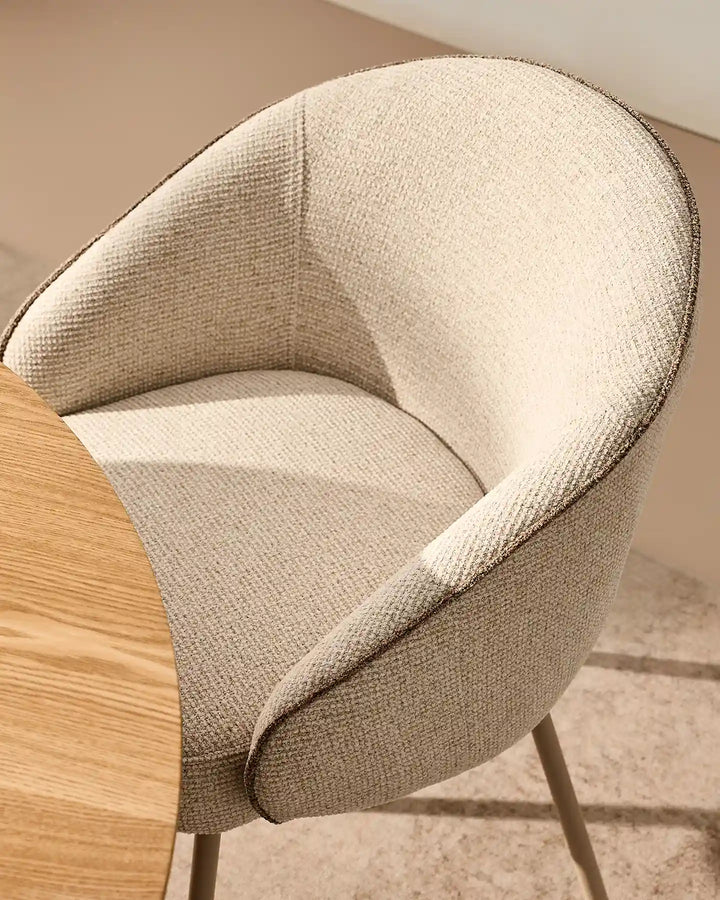 Close-up of the Elowen cream and brown chenille dining chair showing thick padded upholstery and rounded armrests