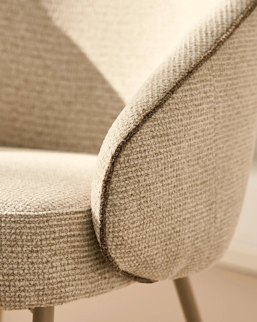 Close-up of the rounded upholstered armrest design on the Elowen cream and brown chenille dining chair