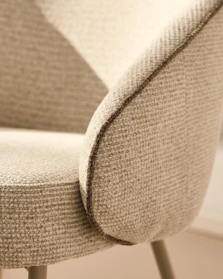 Close-up of the rounded upholstered armrest design on the Elowen cream and brown chenille dining chair