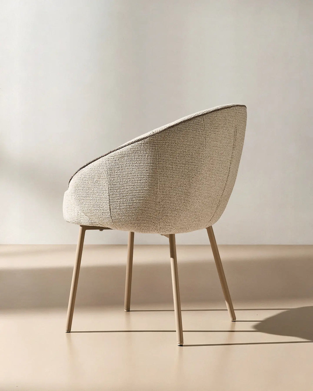 Rear angled view of the Elowen cream and brown chenille dining chair showcasing its modern silhouette and curved upholstered back