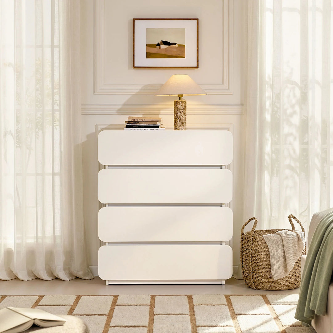 The Ennis 4 Drawer Chest of Drawers is placed beside the bed, creating a clean and modern bedroom look.