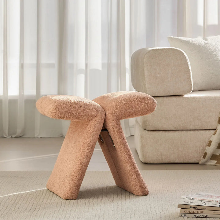 Faye Warm Blush Accent Stool styled beside a sofa in a modern living room, serving as a practical side accent