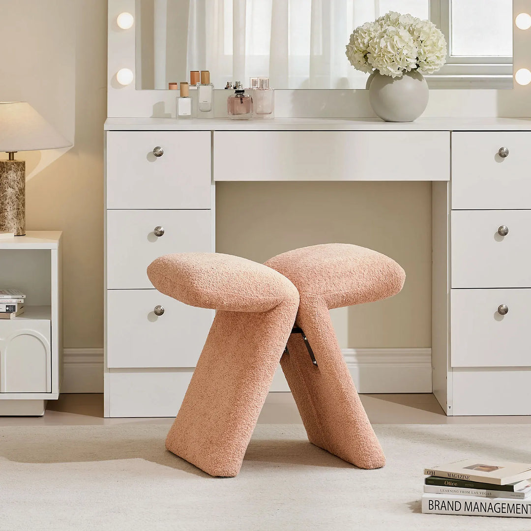 Faye Warm Blush Accent Stool used as a vanity stool in a bedroom, positioned in front of a white dressing table