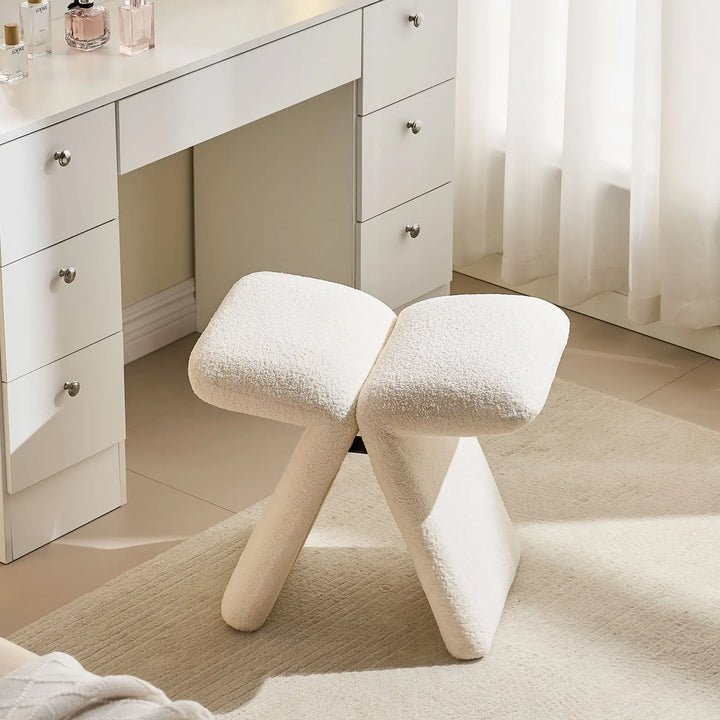 Top view of the Faye warm white Accent Stool used as a vanity stool, showcasing its butterfly-shaped seat.
