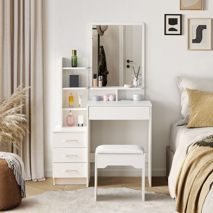The front view of the white dressing table set, with a mirror, a 3-drawer cabinet, a big drawer under the tabletop, several shelves, and a stool, in a bright bedroom.