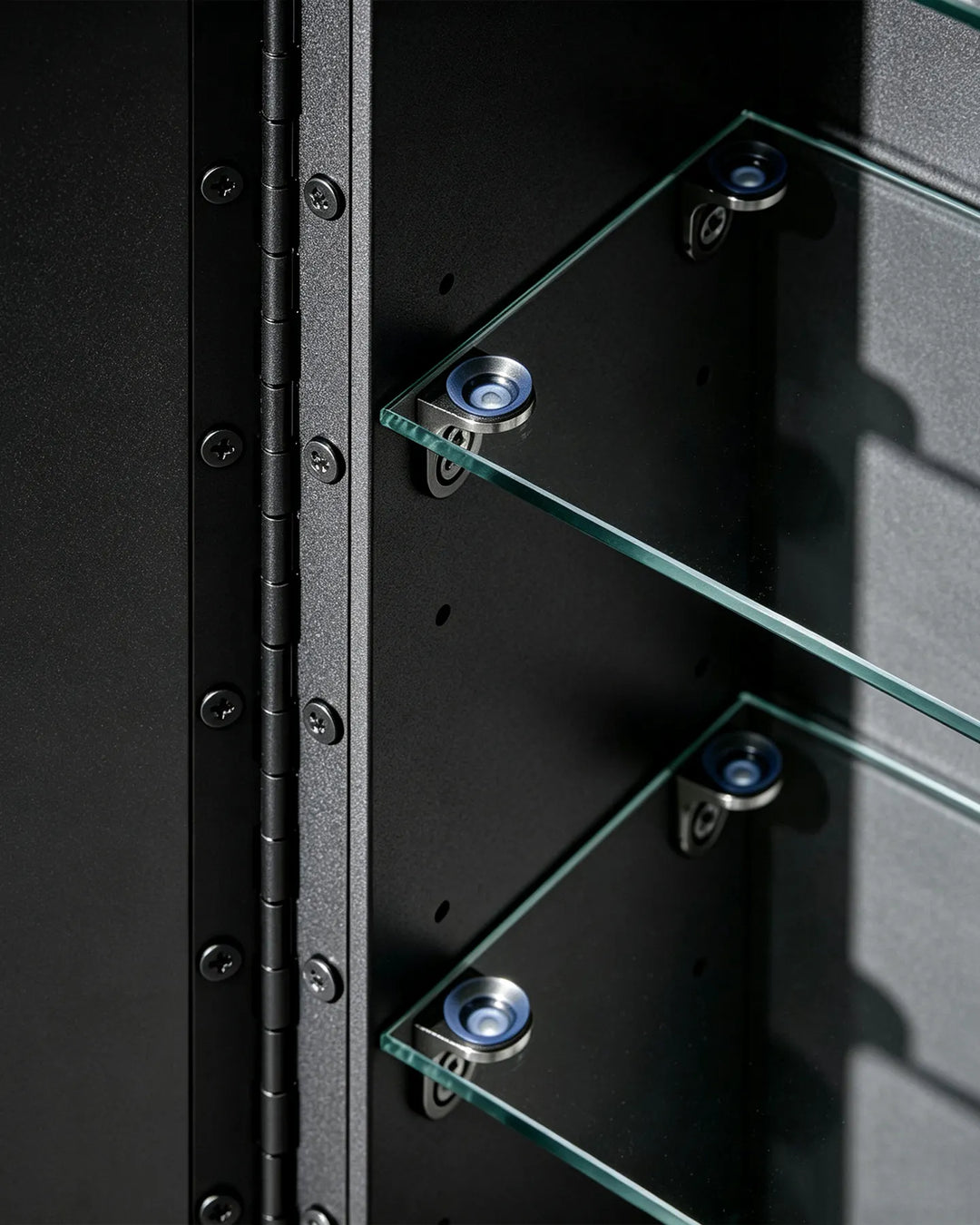 Detailed view of piano hinge and glass shelf brackets inside the black Arcadia cabinet.
