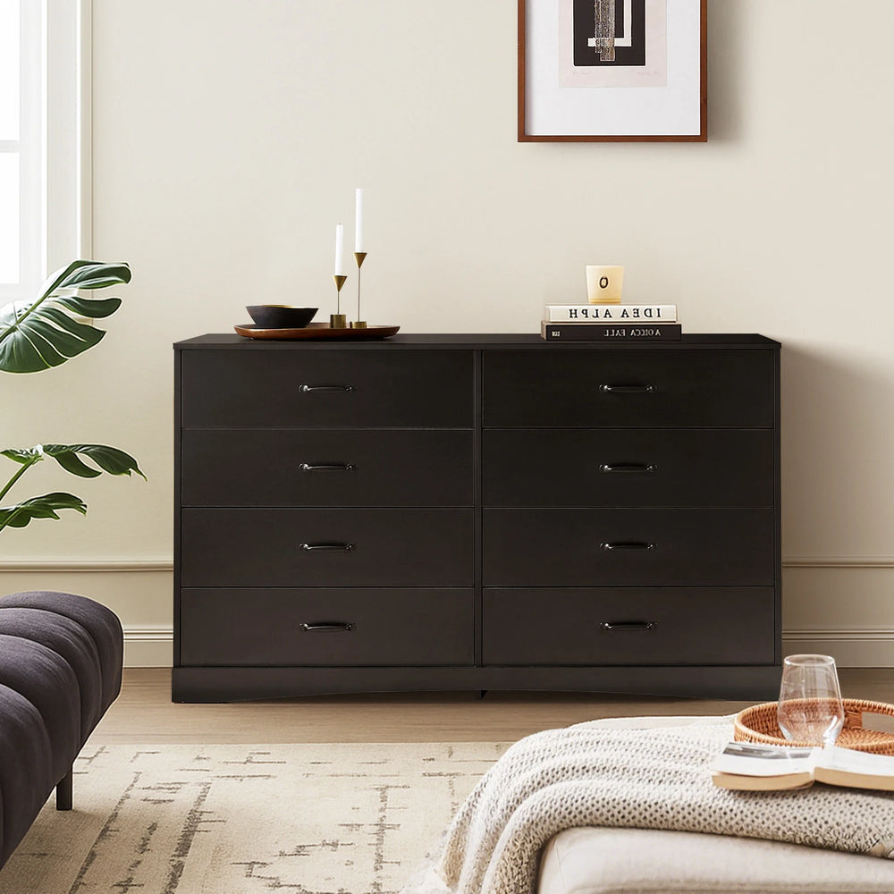 Kamai black 8-drawer chest in airy living room with sofa and plants, by window, styled with decorative items