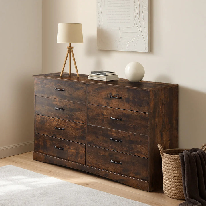 Kamai rust brown chest of drawers in warm bedroom, top surface with table lamp and stacked books.