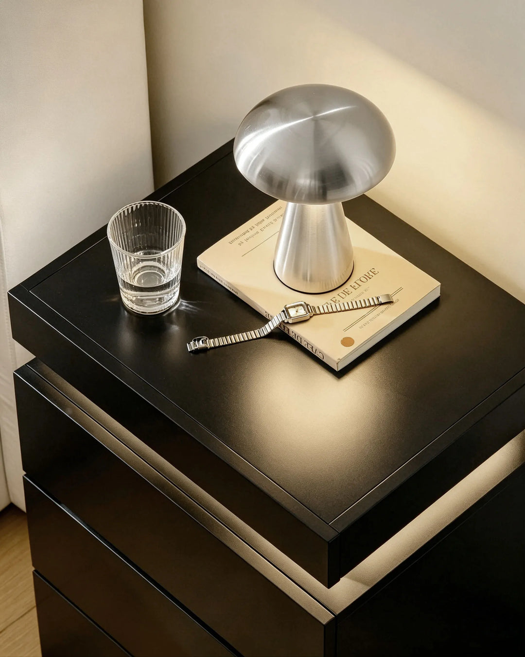 Close-up of black Kumar bedside table high gloss surface, smooth reflective finish detail