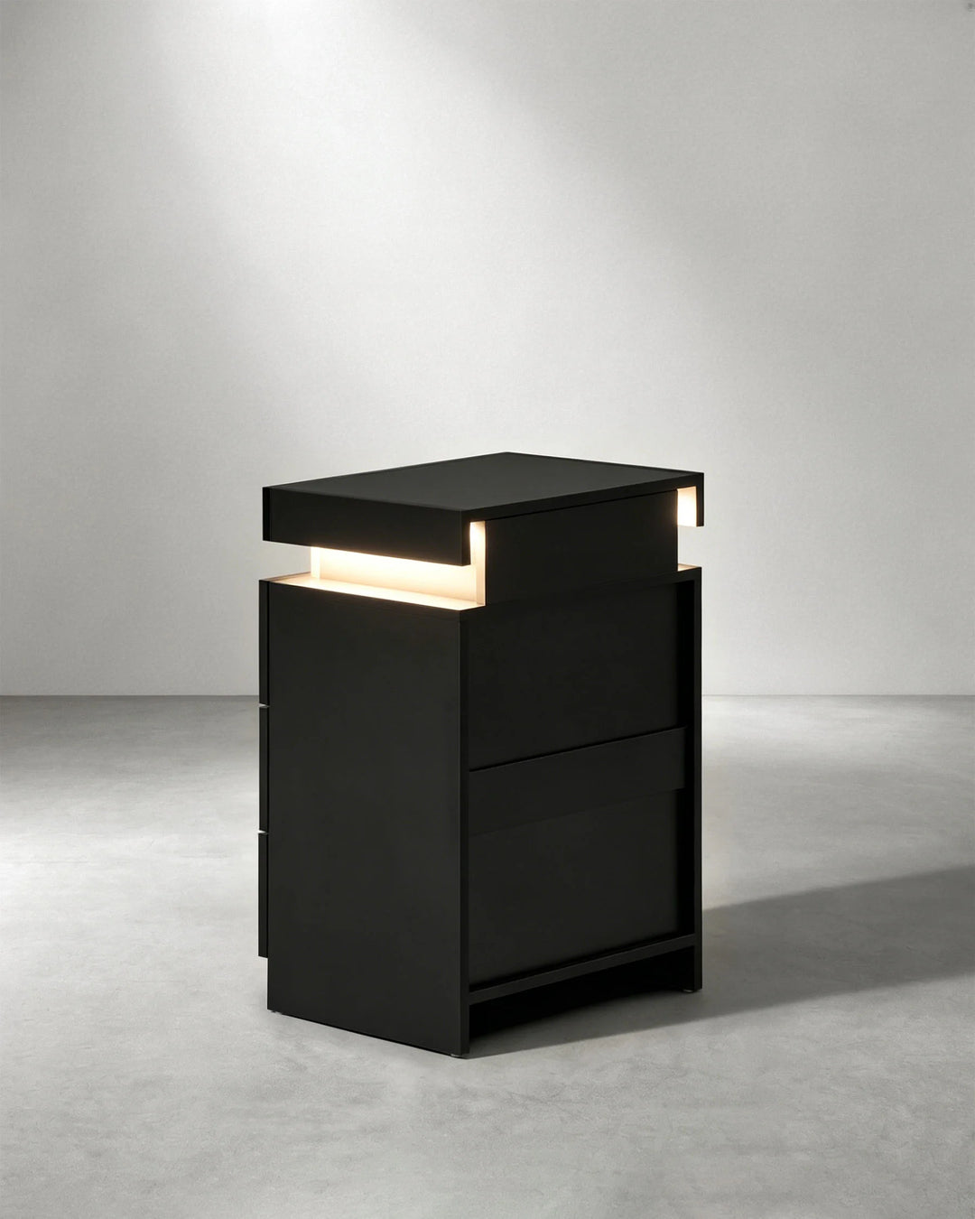 Rear angled view of black Kumar LED bedside cabinet, modern bedroom nightstand with high gloss finish