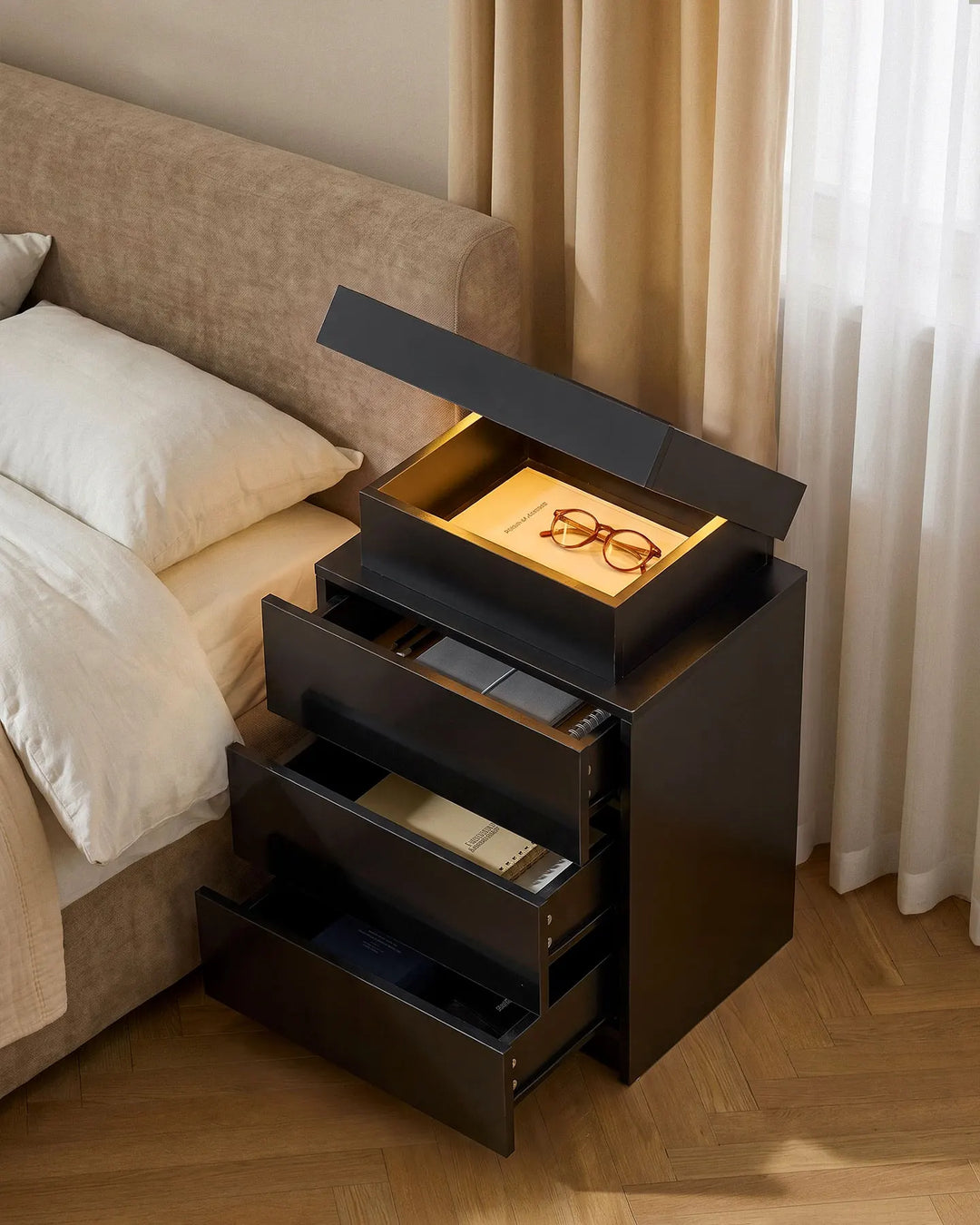 Black smart bedside table with all drawers and the hidden top lid open.