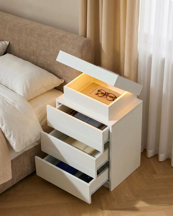 White smart nightstand with all drawers and the top hidden compartment fully open.
