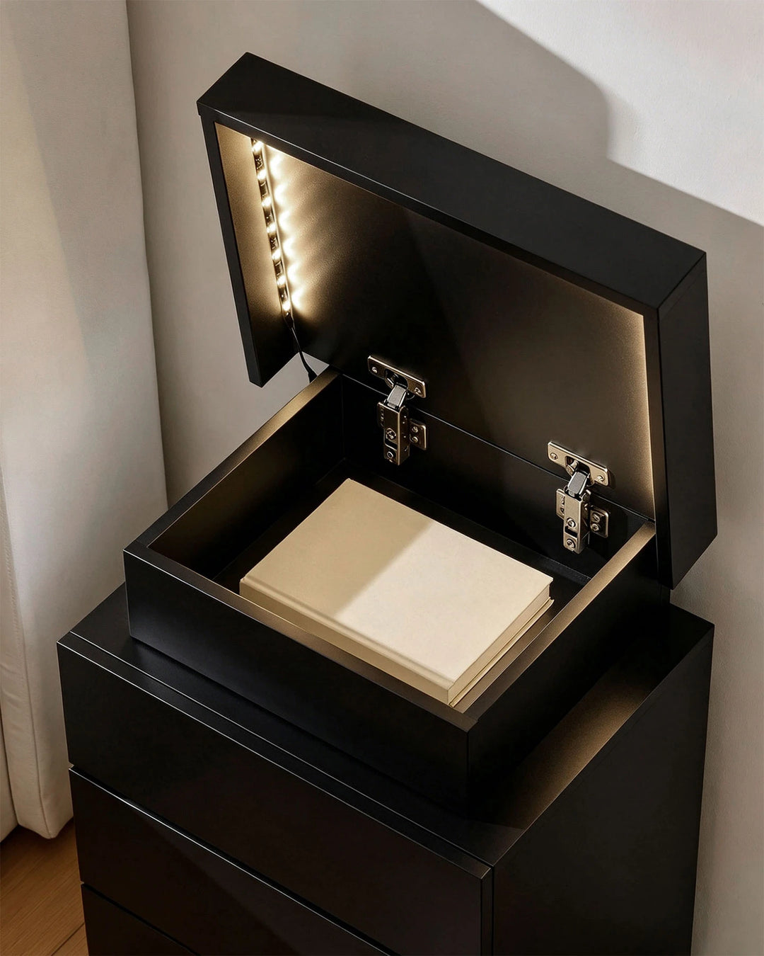 Black smart table with the top lid open revealing a lighted hidden organiser compartment.
