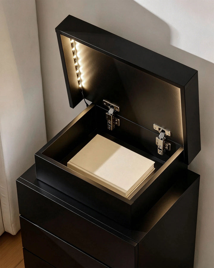 Black smart table with the top lid open revealing a lighted hidden organiser compartment.