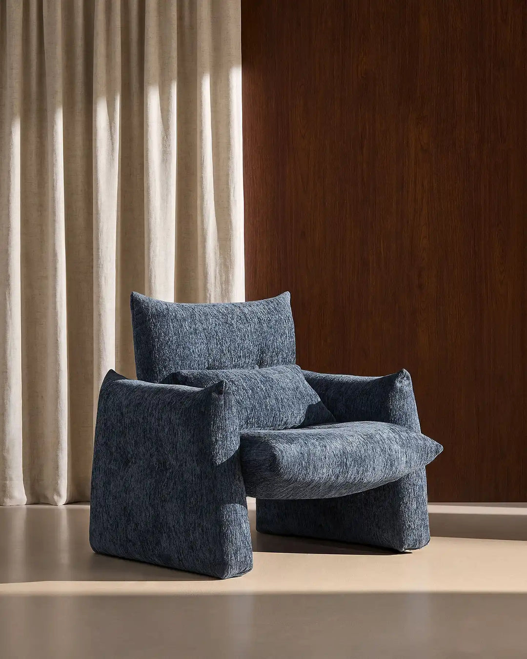 Rear side view of the Navy Blue Kumo Accent Chair showcasing its soft curved contemporary silhouette