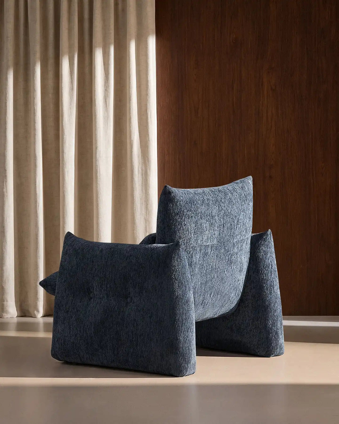 Rear side view of the Navy Blue Kumo Accent Chair showcasing its soft curved contemporary silhouette