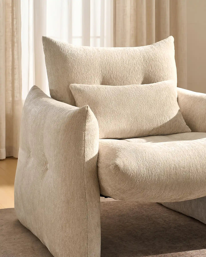 Close-up of the Kumo Accent Chair's rounded armrests and deep padded chenille seat cushion in cream