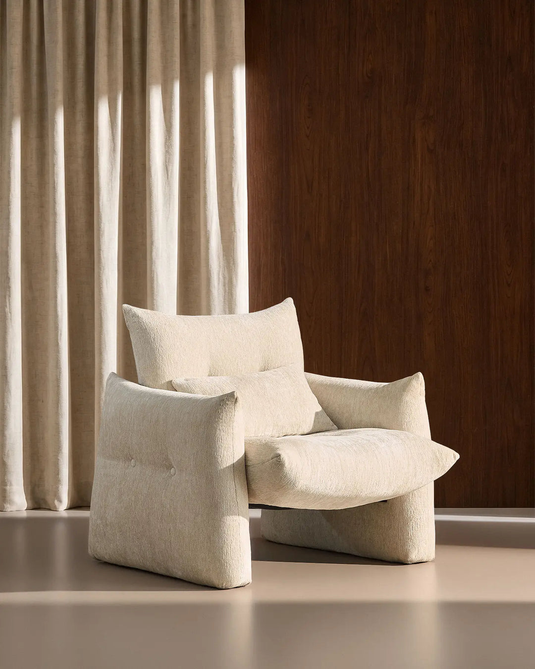 Side profile of the cream Kumo Accent Chair showing its oversized seat and rounded contemporary design